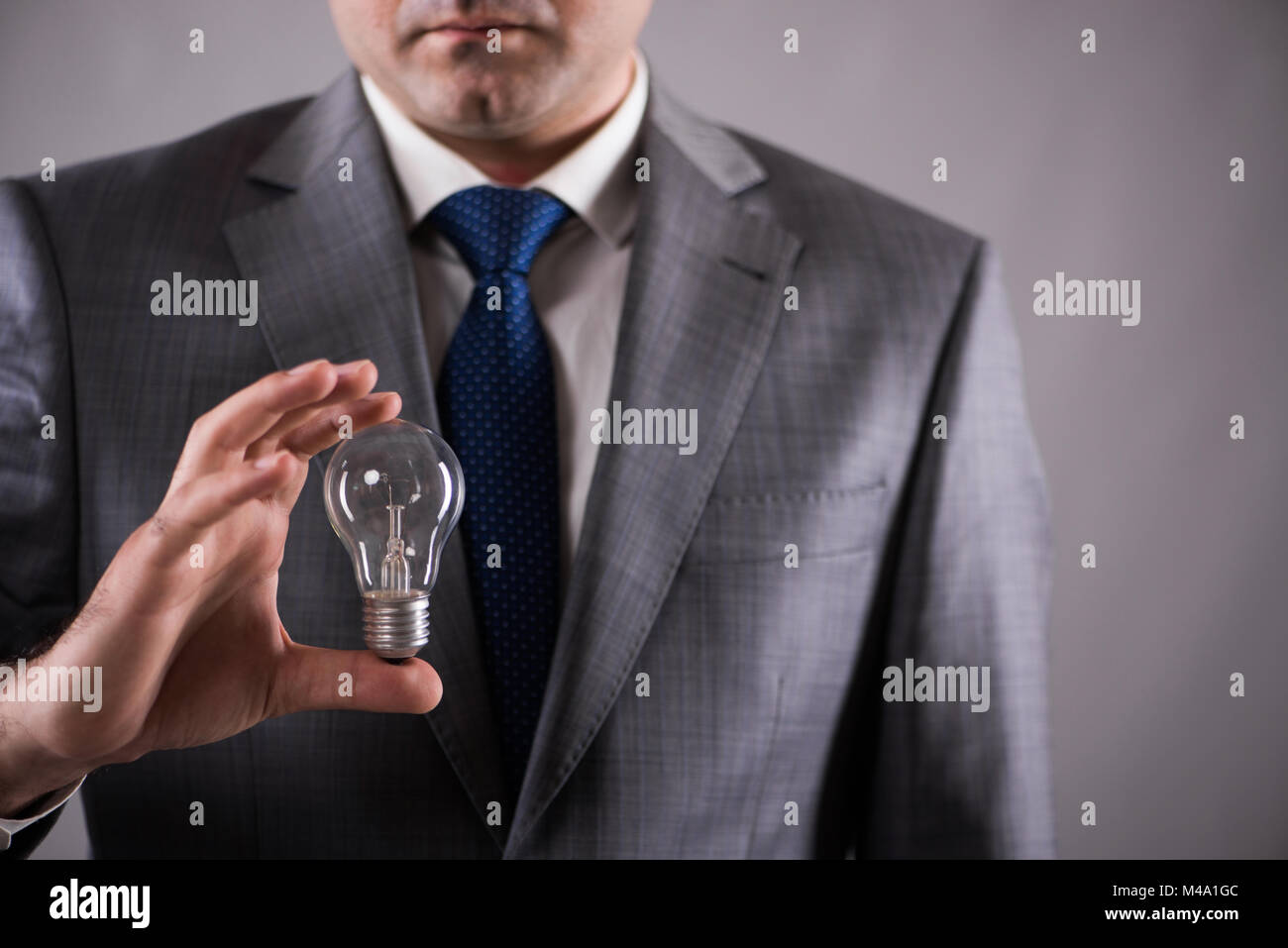 Businessman holding light bulb in creativity concept Stock Photo - Alamy