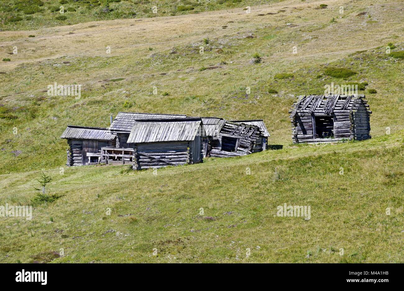 weather-beaten wooden cabins on a seasonal alpine pasture Stock Photo