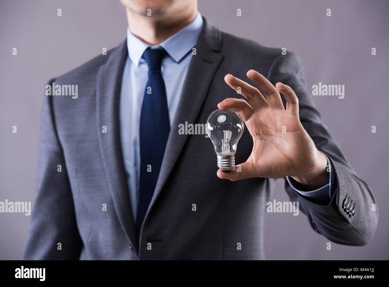 Businessman holding light bulb in creativity concept Stock Photo - Alamy