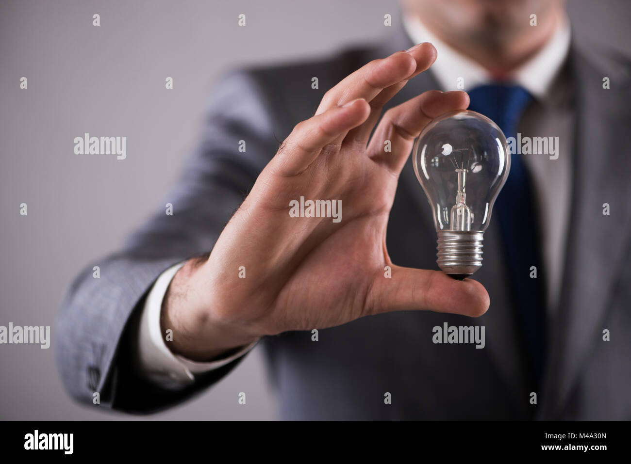 Businessman holding light bulb in creativity concept Stock Photo - Alamy