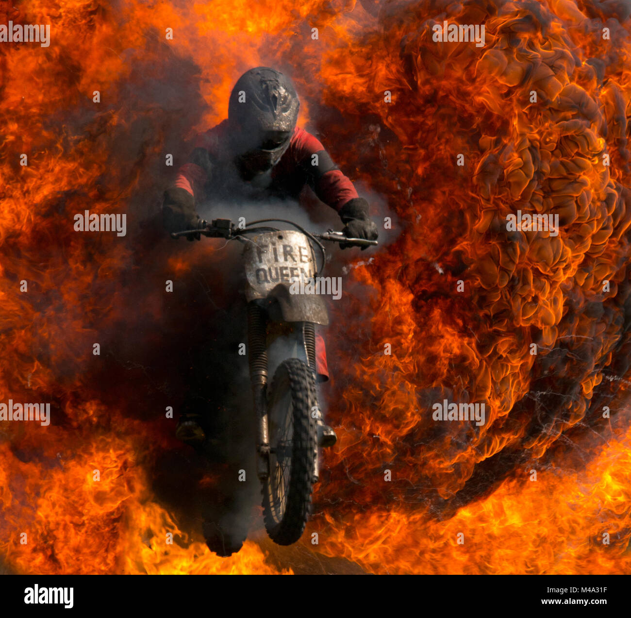 A Motorbike Stunt Rider Emerging Through Fire Stock Photo