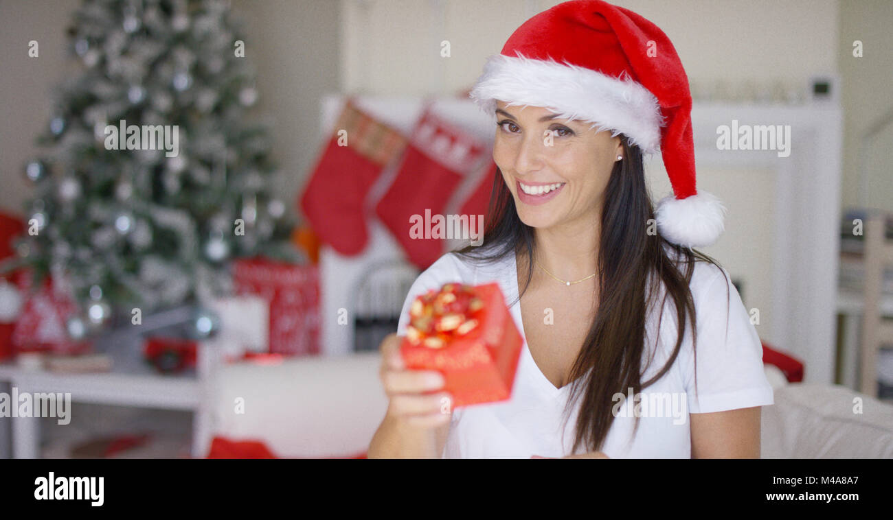 Charismatic young woman holding a Christmas gift Stock Photo