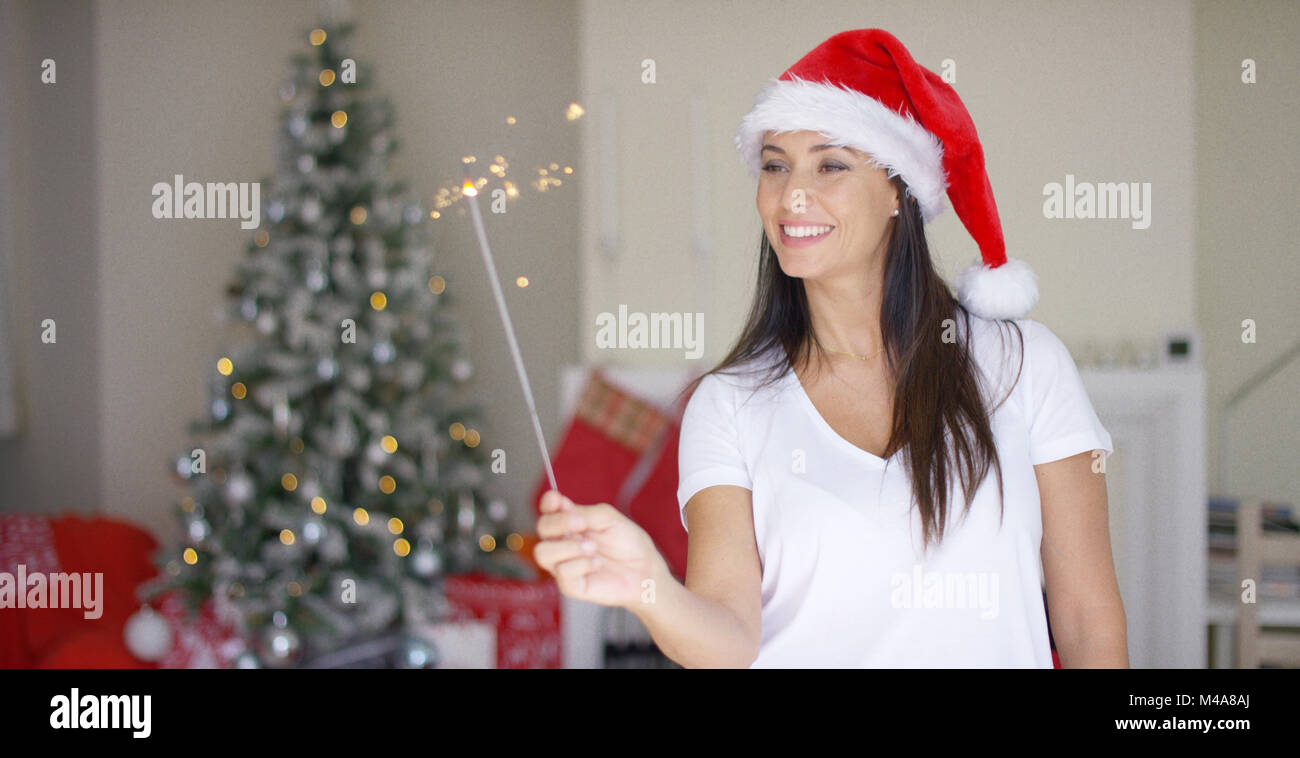 Joyful young woman celebrating Christmas at home Stock Photo