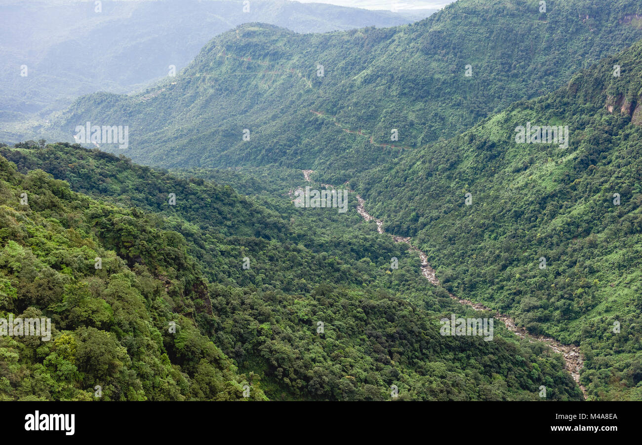 Deep valley in the Khasi hills and river with the rugged slopes of forest and peaks and the border with Bangladesh near Shillong, Meghalaya, India. Stock Photo