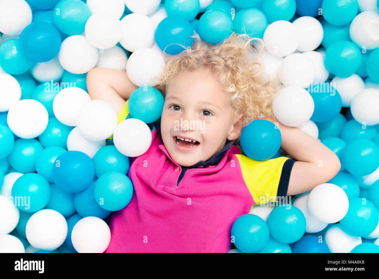 Child playing in ball pit. Colorful toys for kids. Kindergarten or