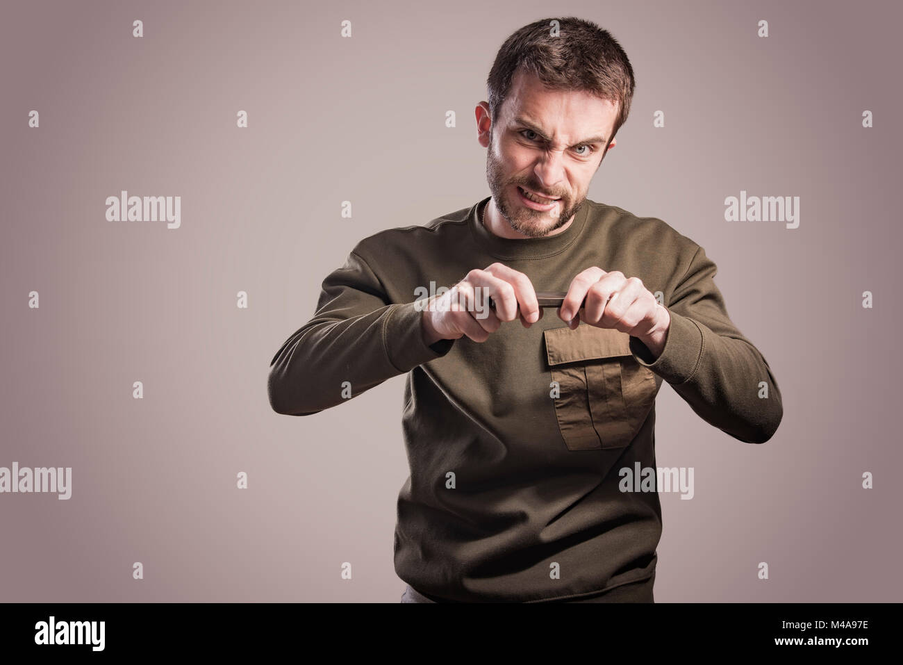 Man angry at his phone, outraged and enraged Stock Photo