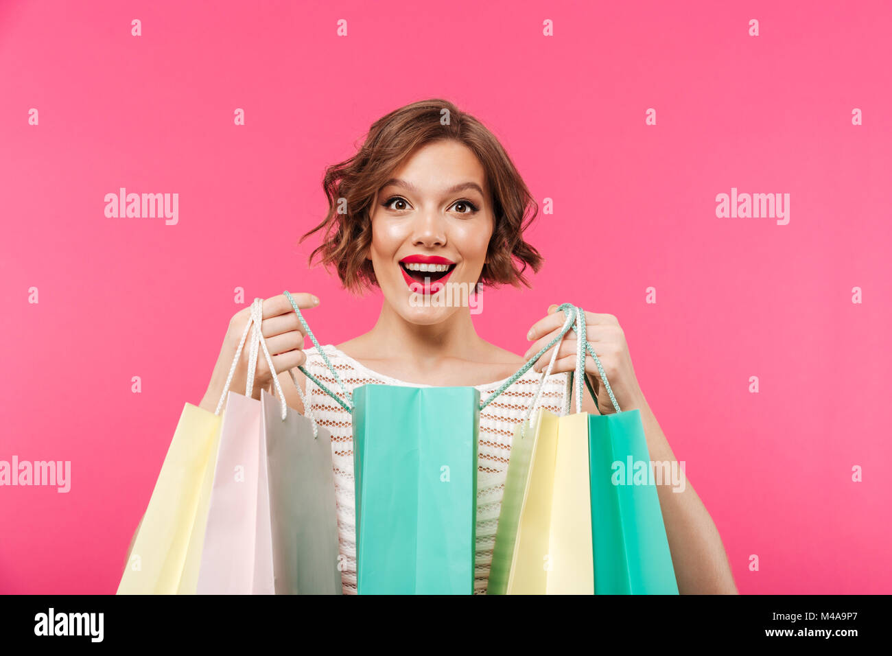 Portrait of a happy girl dressed in dress with opened shopping bags ...
