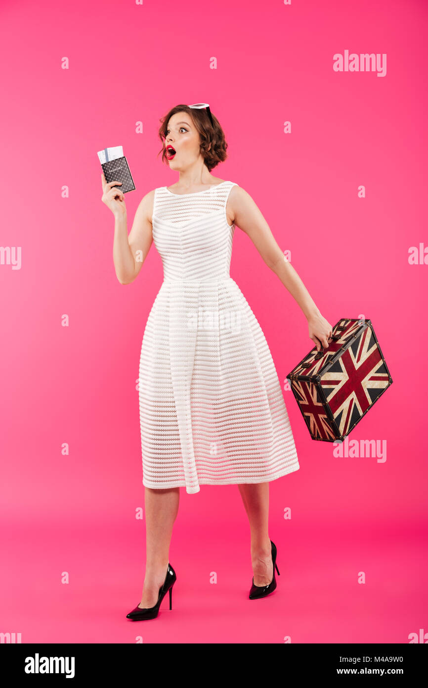 Full length portrait of an excited girl dressed in dress holding ...