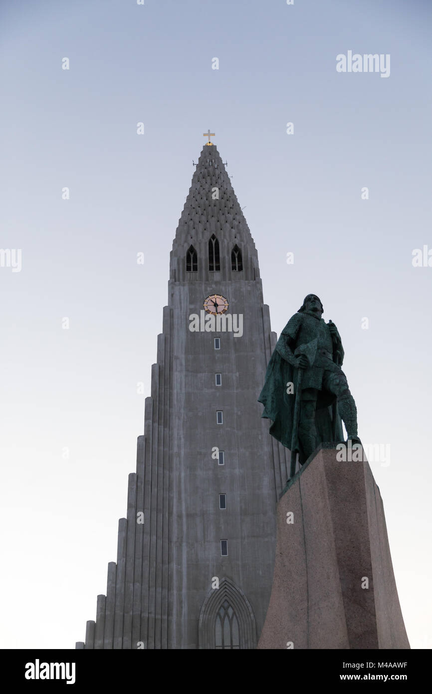 The steeple of Hallgrímskirkja, a large Lutheran church in Reykjavik, Iceland, and a statue of Leif Ericson on a winter morning under clear skies Stock Photo