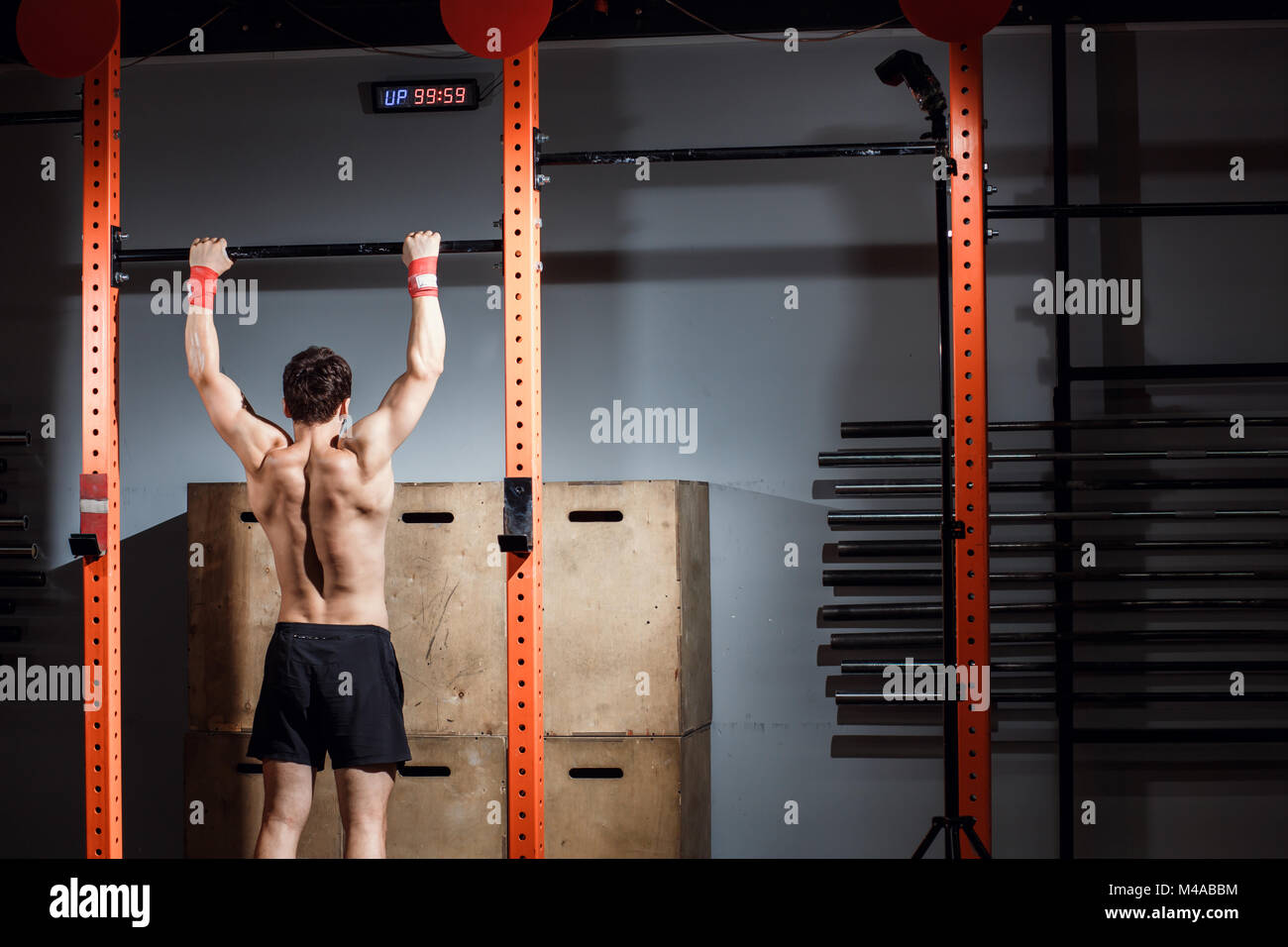 attractive young male adults doing pull ups on bar in cross fit
