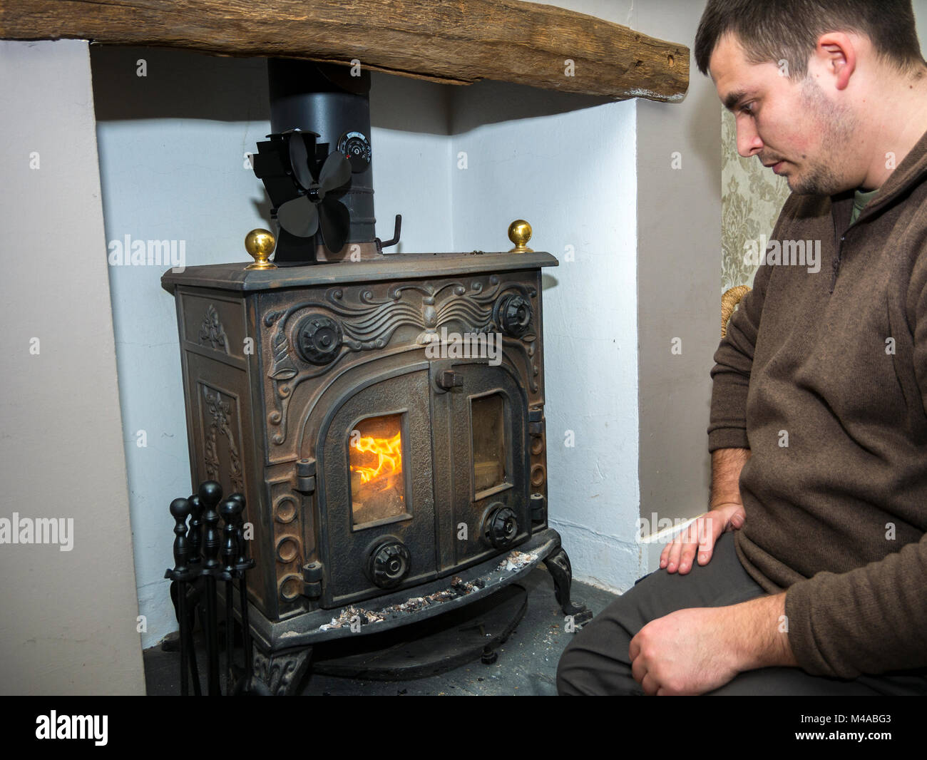 Man lighting traditional wood burning stove Stock Photo