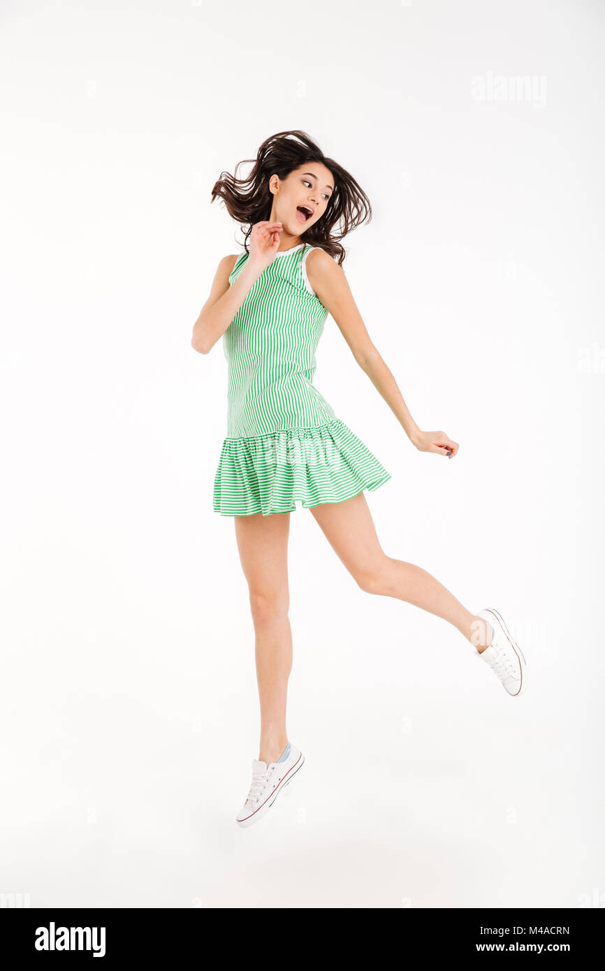 Full length portrait of a pretty girl dressed in dress posing while ...