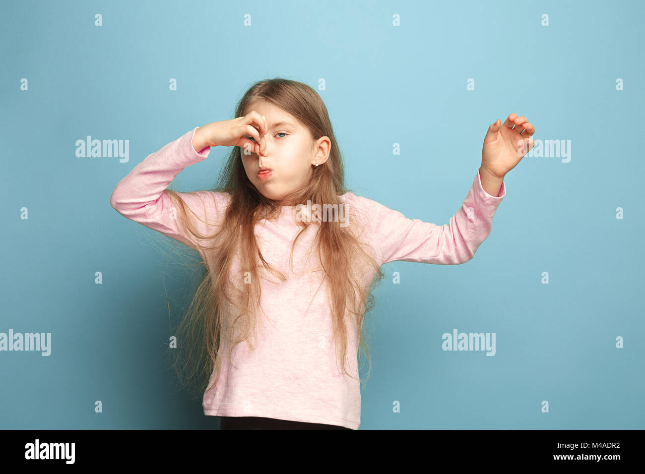 The Disgust. Teen Girl On A Blue Background. Facial Expressions And 