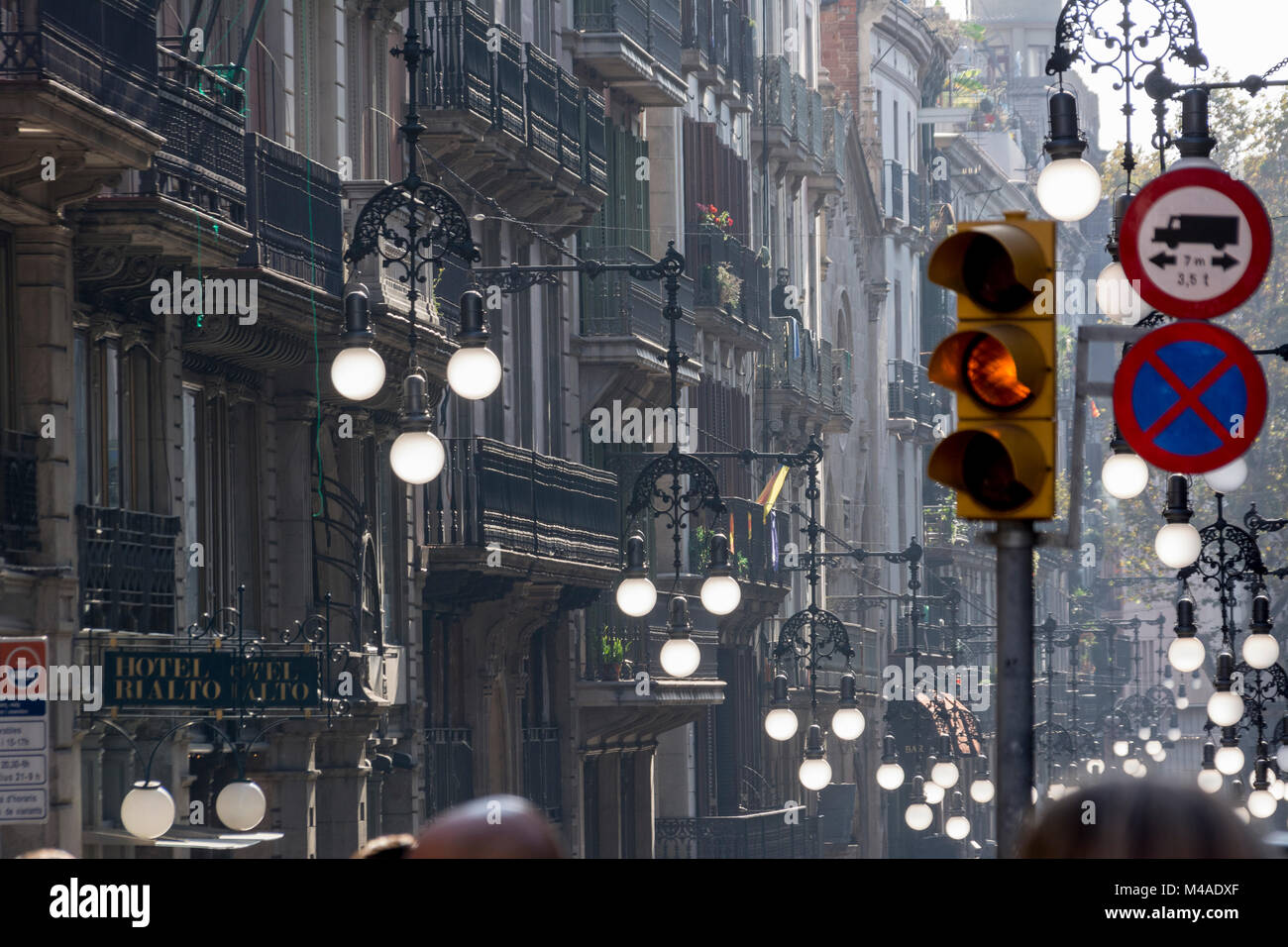 Straßenszene in Barcelona mit von der Sonne durchleuchteten Straßenlampen Stock Photo