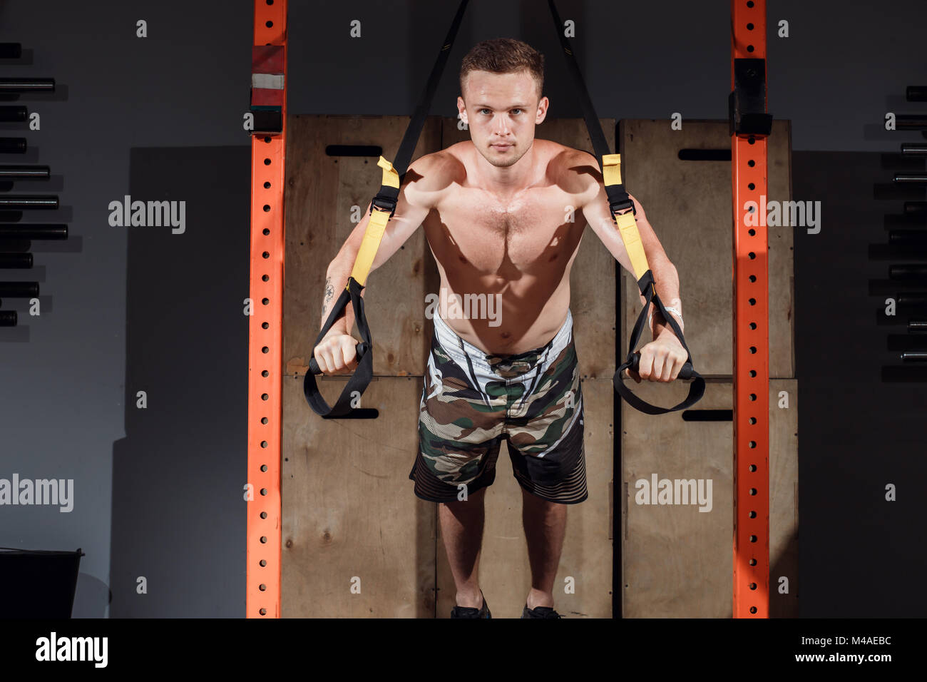 TRX training. Crossfit instructor at the gym doing TRX Excersise. Stock Photo