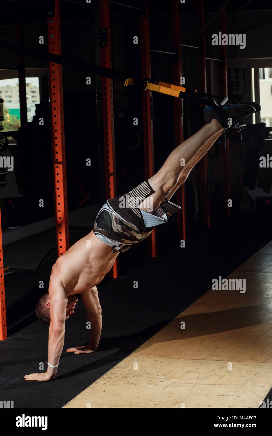 male and athletic male doing trx straps exercises in a gym club Stock ...