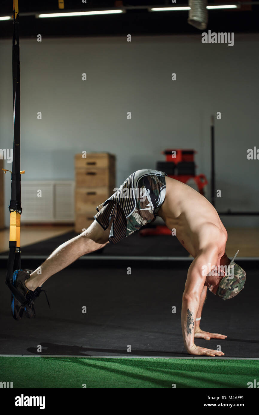 male and athletic male doing trx straps exercises in a gym club Stock ...