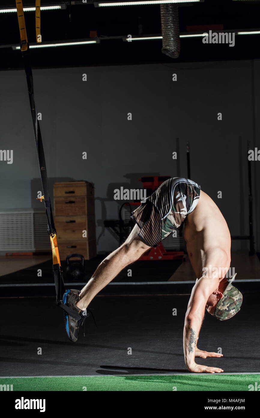 male and athletic male doing trx straps exercises in a gym club Stock ...