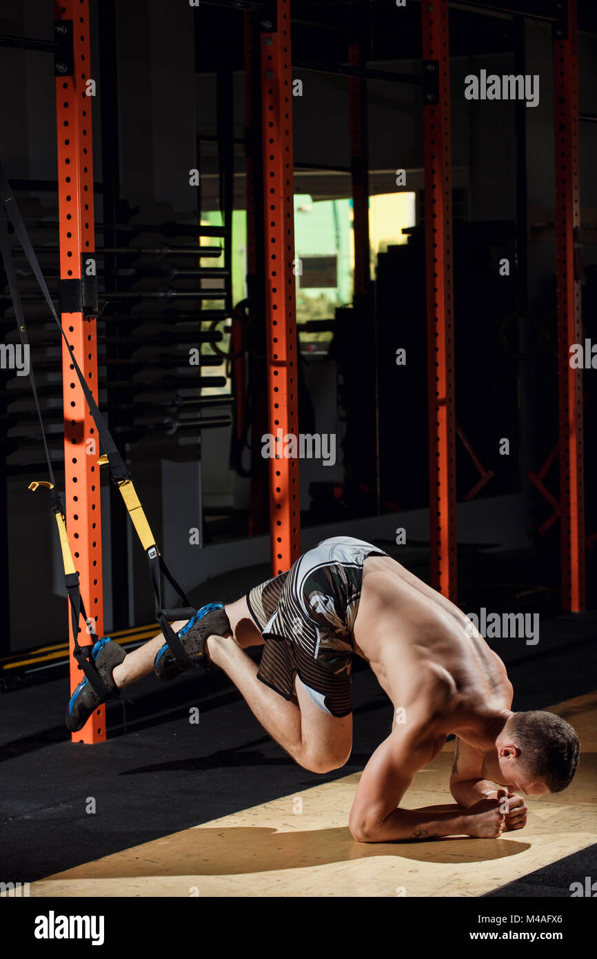 male and athletic male doing trx straps exercises in a gym club Stock ...