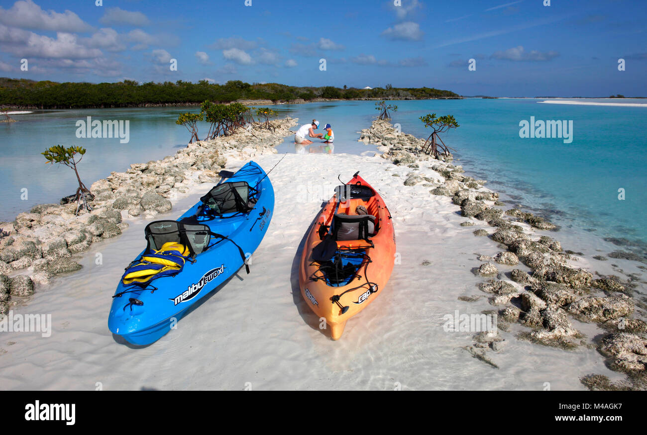 A mother and son play in the shallow clear Bahamian waters while kayaking near Man-O-War Cay just off the island of Great Exuma in the Bahamas. Stock Photo
