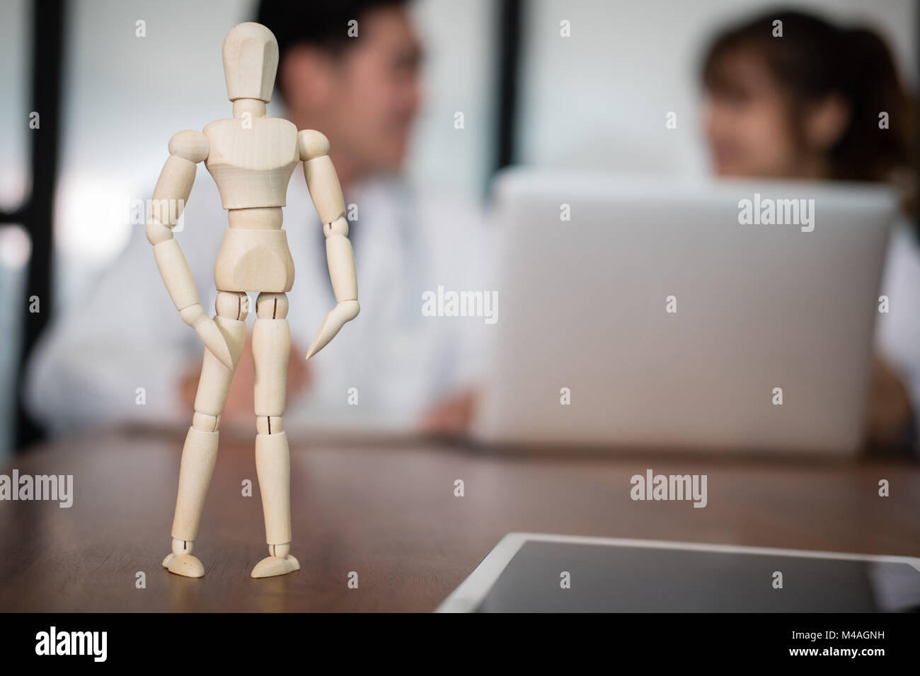 wood figure with doctor discussing patient treatment. medical staff have meeting for diagnosis plan in conference room in hospital. Stock Photo