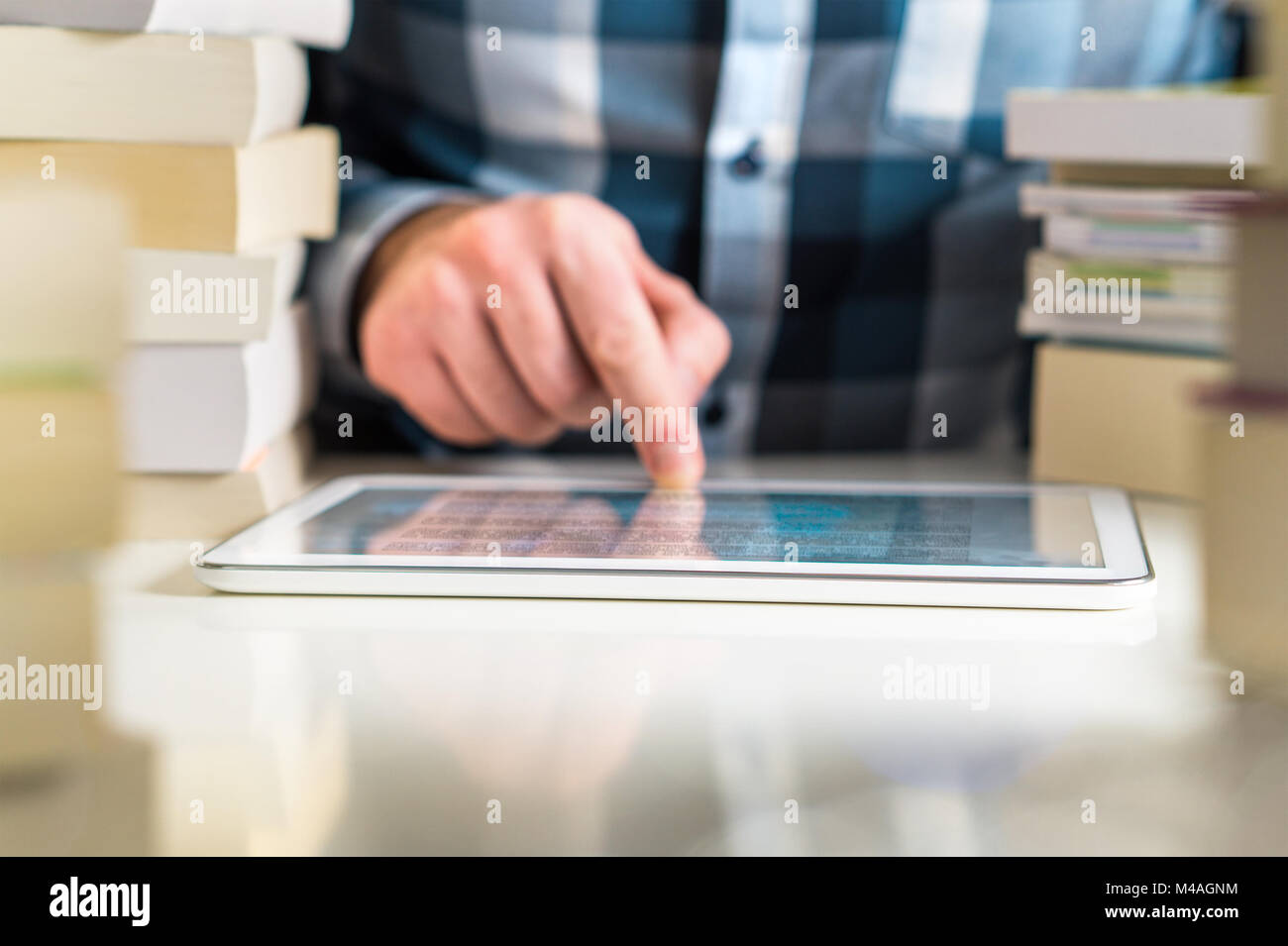 Man reading electronic book with reader. Touching screen with finger