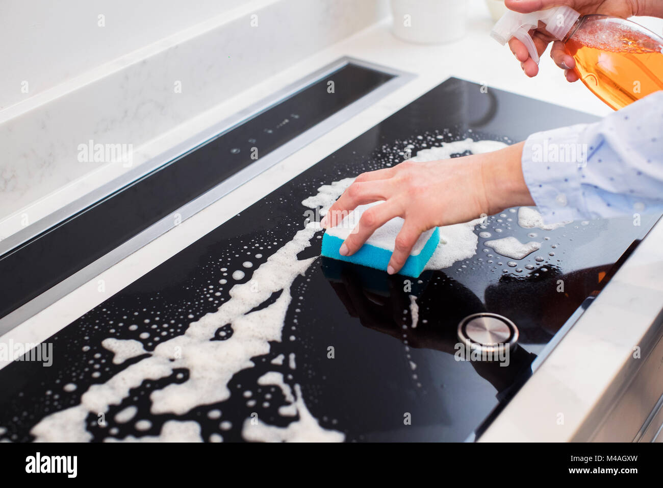 Close Up Of Woman Cleaning Kitchen Hob Stock Photo