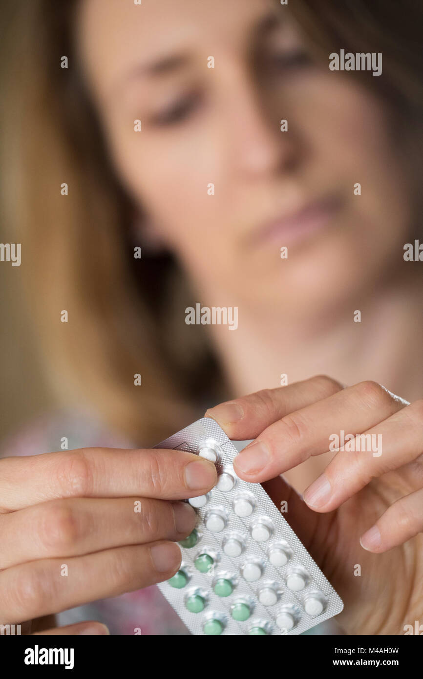 Mature Woman Taking HRT Medication For Symptoms Of Menopause Stock Photo