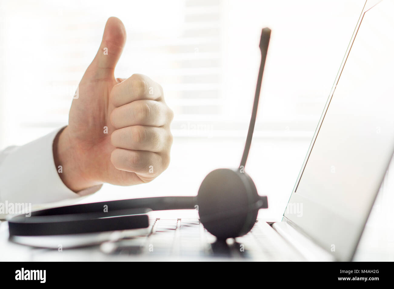 Happy help desk, support hotline or call center person showing thumbs up. Tele marketing professional getting sales. Good feedback. Stock Photo