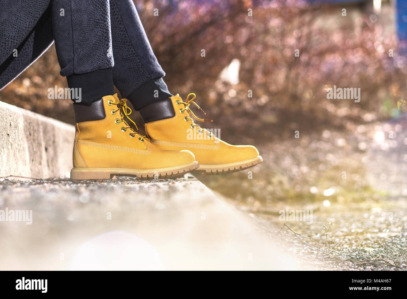 Trendy girl wearing yellow boots. Young woman with light brown shoes. Fashion lifestyle with autumn vibe. Stock Photo