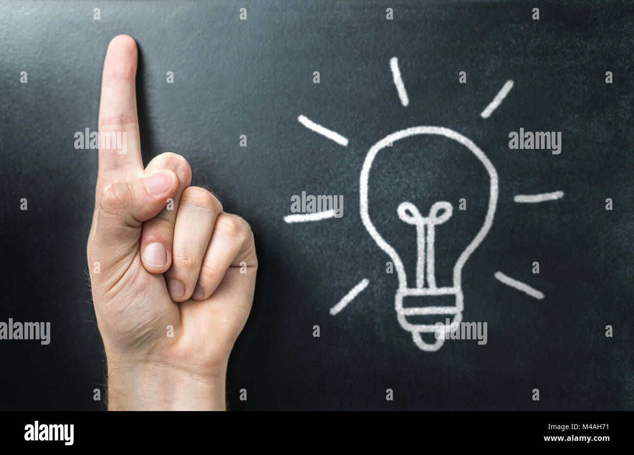 Getting new idea. Innovative, inspiring and creative learning and teaching. Teacher, educator, trainer or student pointing up with finger. Light bulb Stock Photo