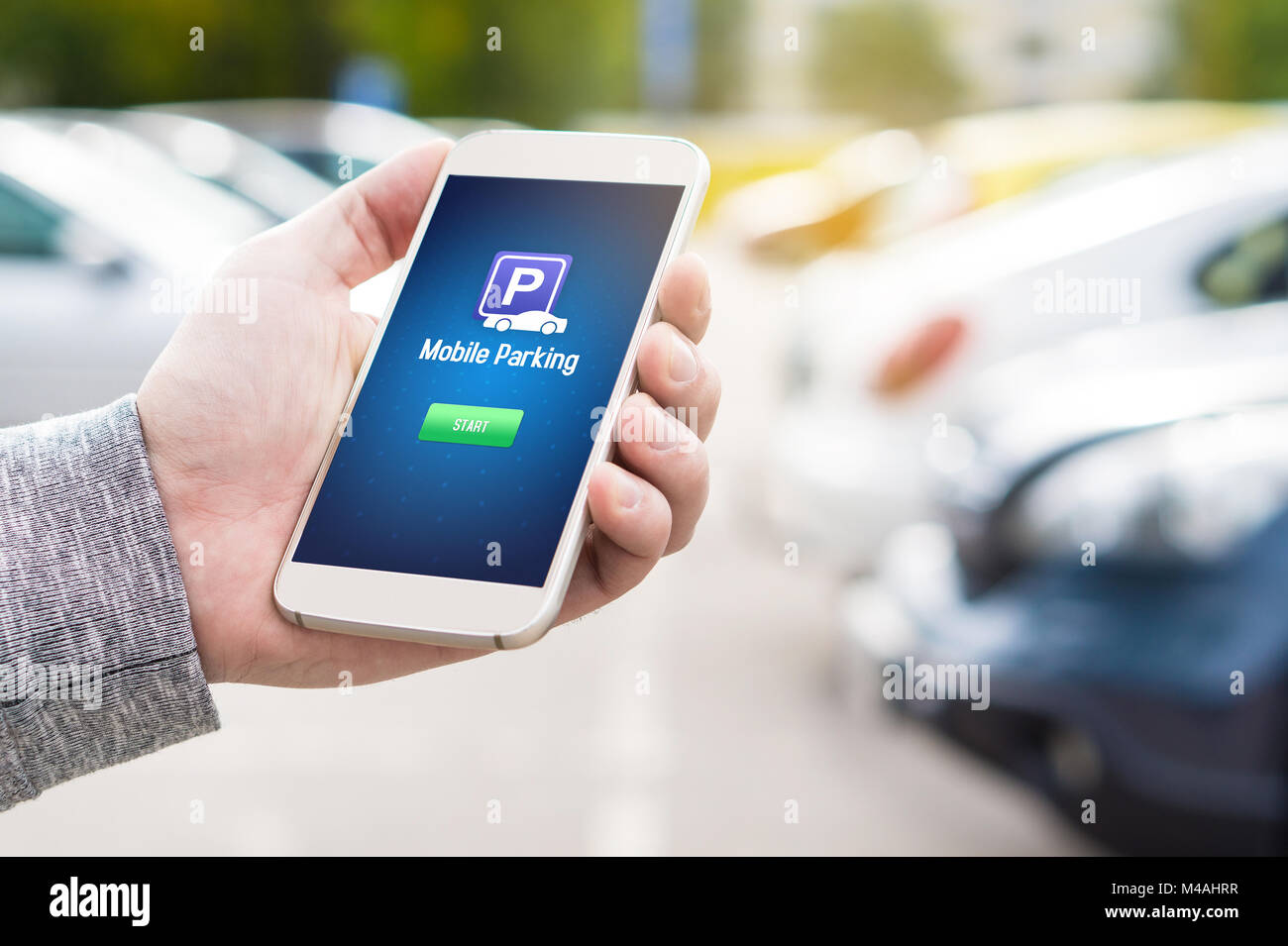 Mobile parking app on smartphone screen. Man holding smart phone with car park application in hand. Internet payment online with modern device. Stock Photo