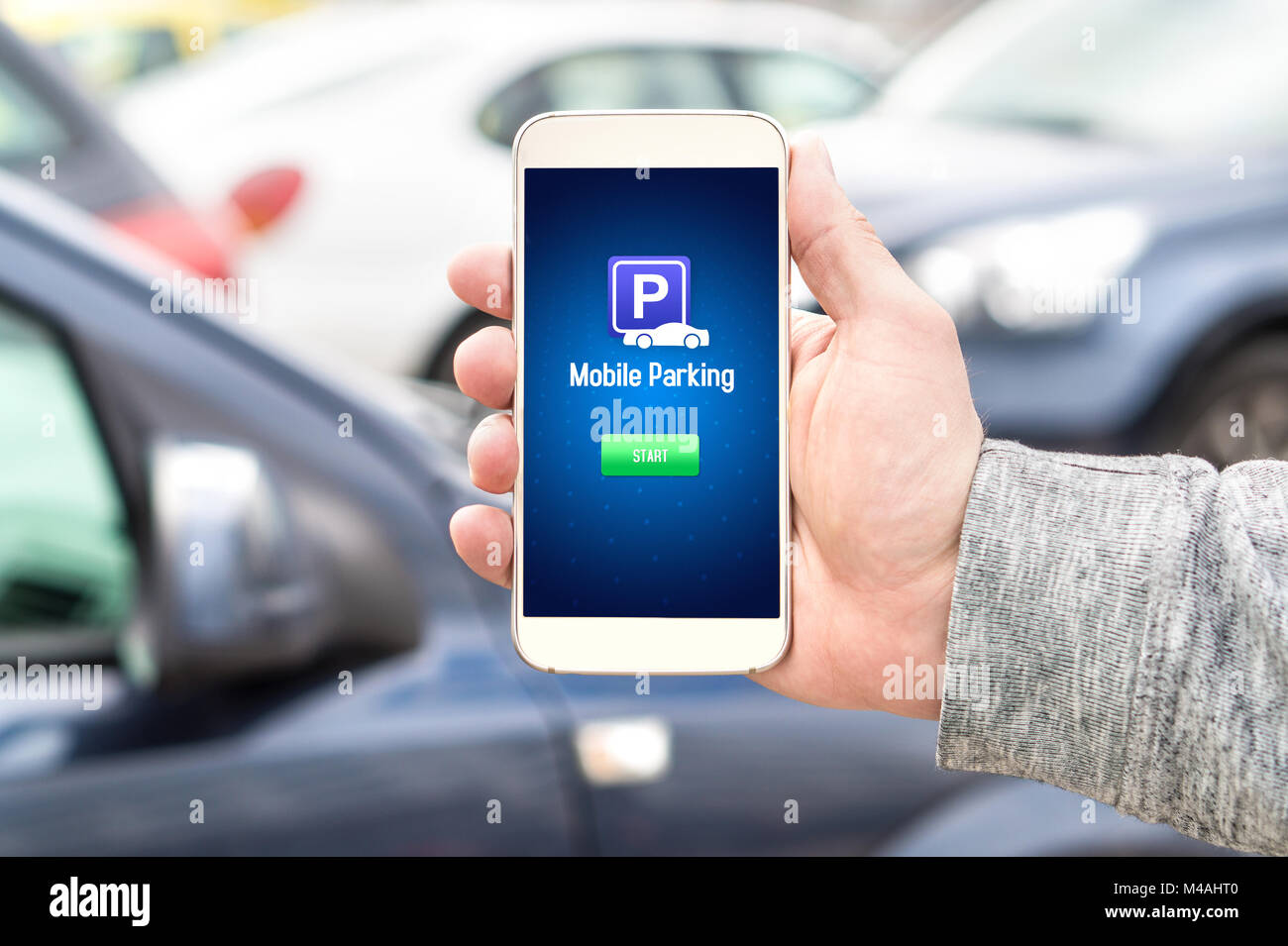 Mobile parking app on smartphone screen facing camera. Man holding smart phone with car park application in hand. Internet payment online. Stock Photo