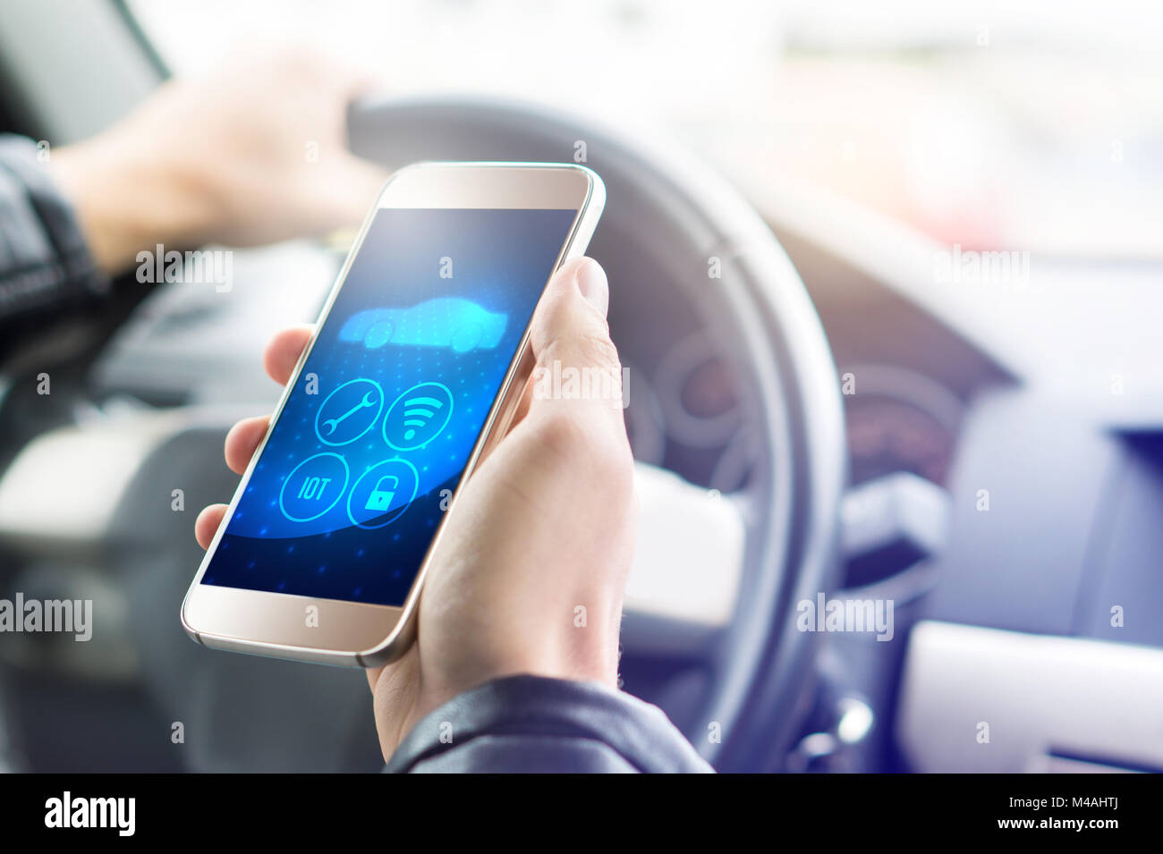 Internet of things (IOT) mobile app in smart phone for modern car. Hand holding smartphone with futuristic ADAS system. Stock Photo