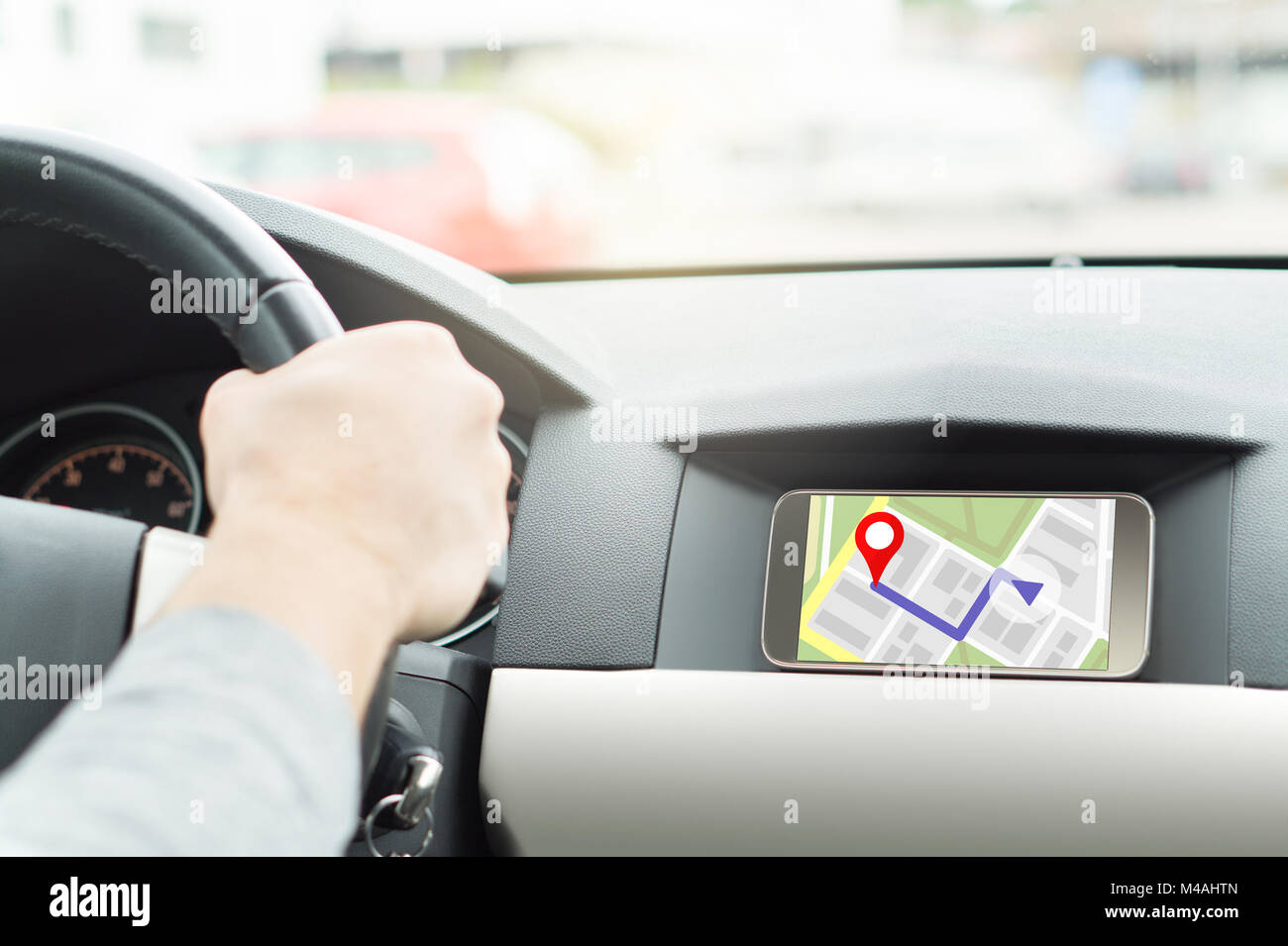 Man driving car and navigating. Mobile app in smartphone. Online map and GPS application on cellphone screen. Interior cockpit view. Stock Photo