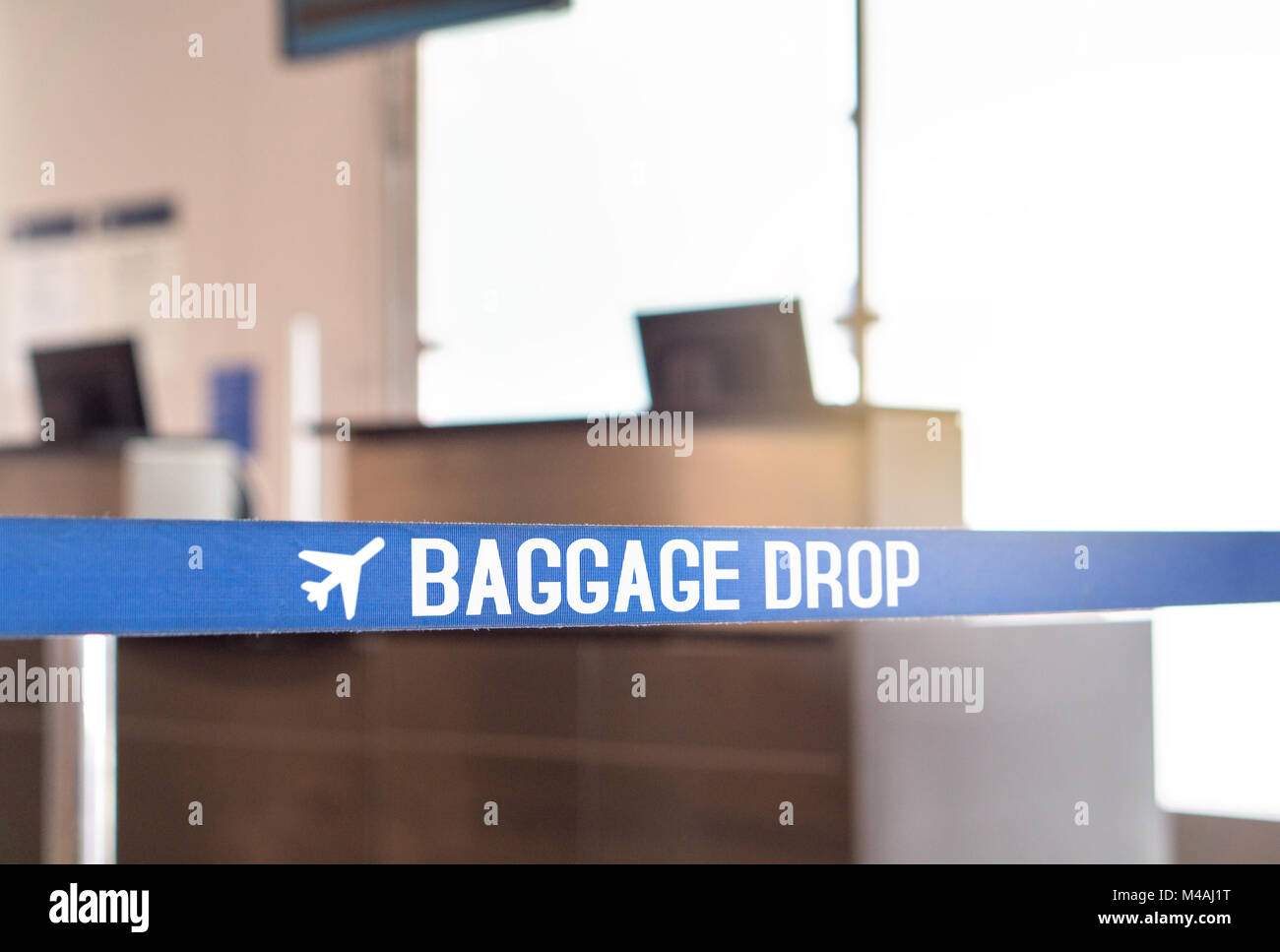 Baggage drop at airport. Luggage desk in terminal. Stock Photo