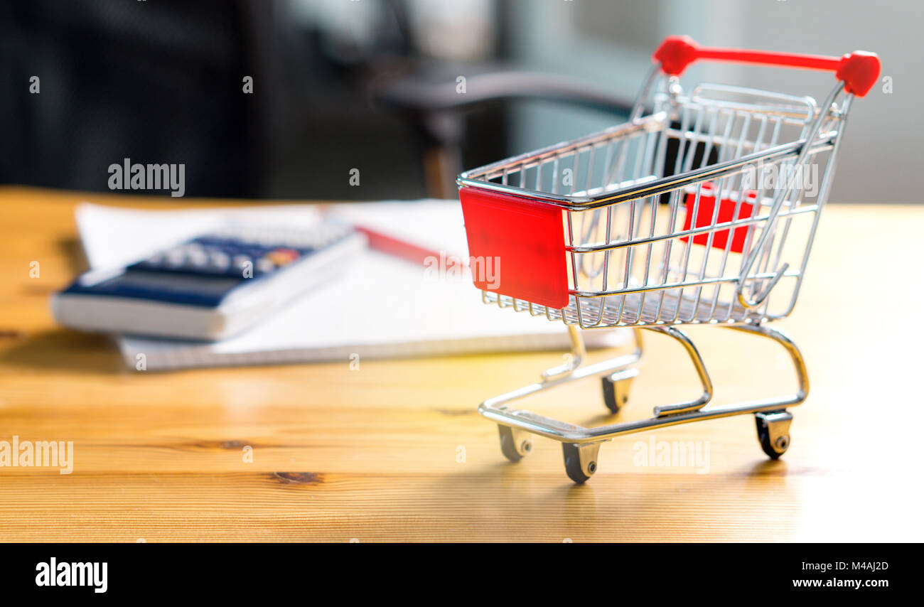 Budget of poor and low income family. Rising food and grocery store prices and expensive daily consumer goods concept. Miniature shopping cart. Stock Photo
