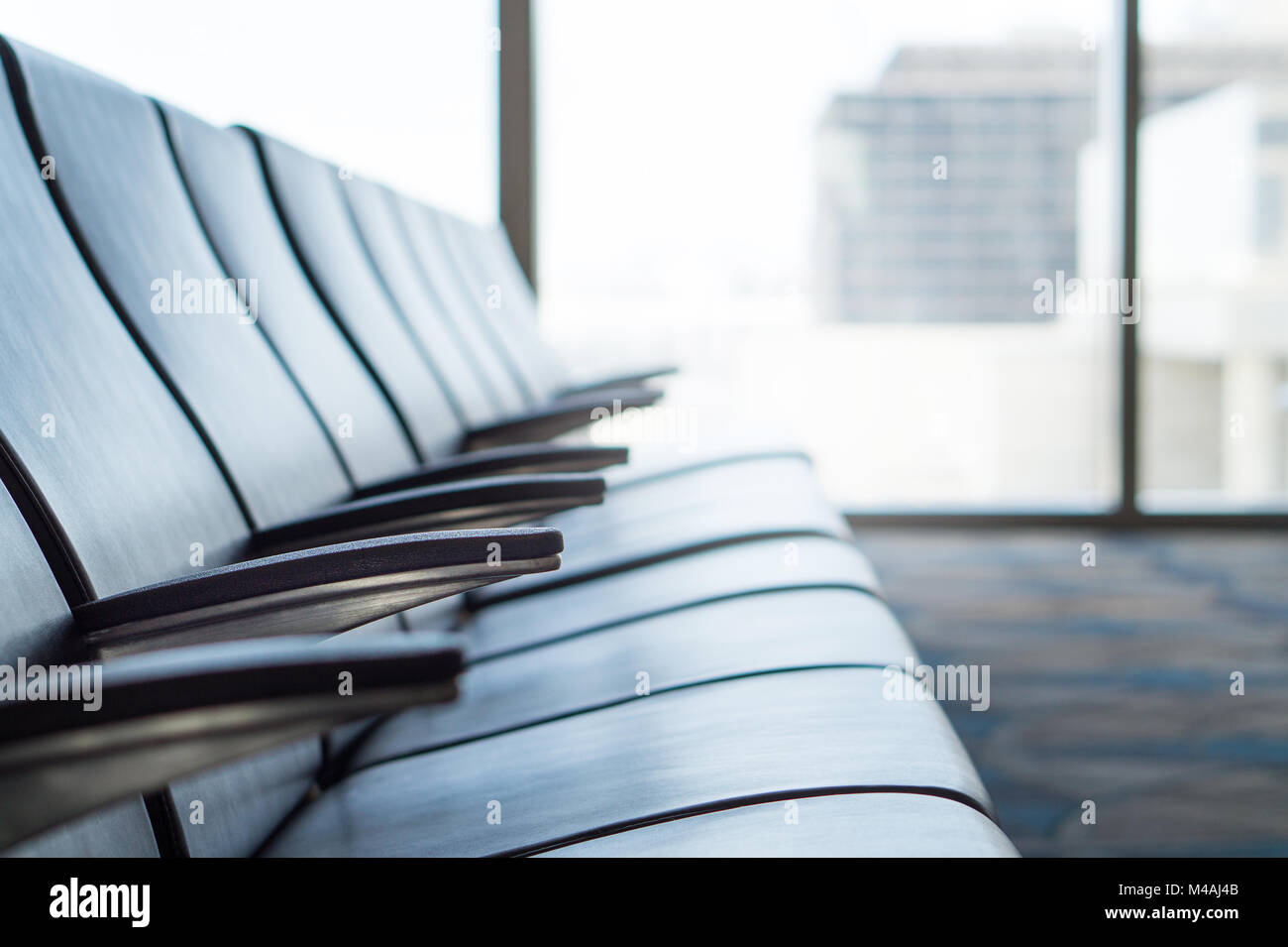 Airport waiting room at terminal. Departure lounge. Empty seats at gate. Light from window. Stock Photo