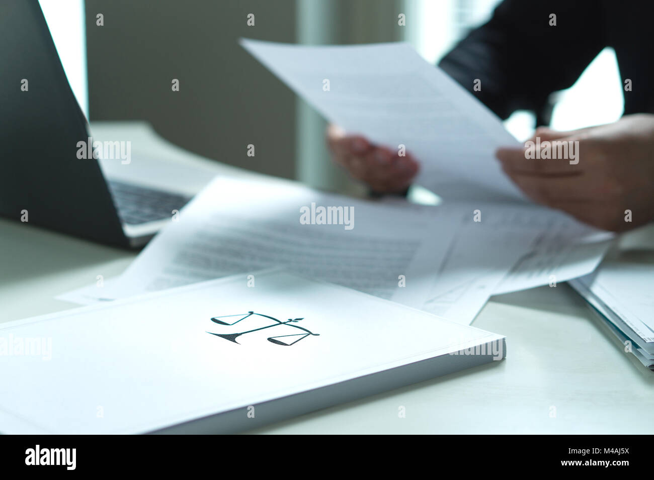 Man holding a legal document in hand. Lawyer holding law paper in office. Scale and justice symbol. Stock Photo