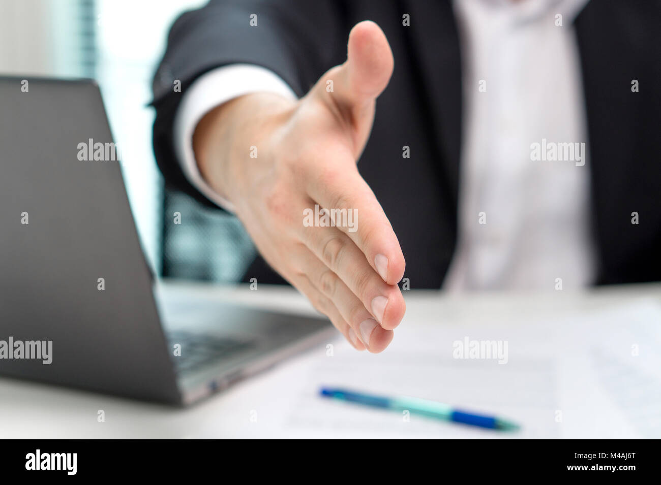 Business man offer and give hand for handshake in office. Salesman, bank worker or lawyer shake for deal, agreement, loan or sale. Partnership. Stock Photo