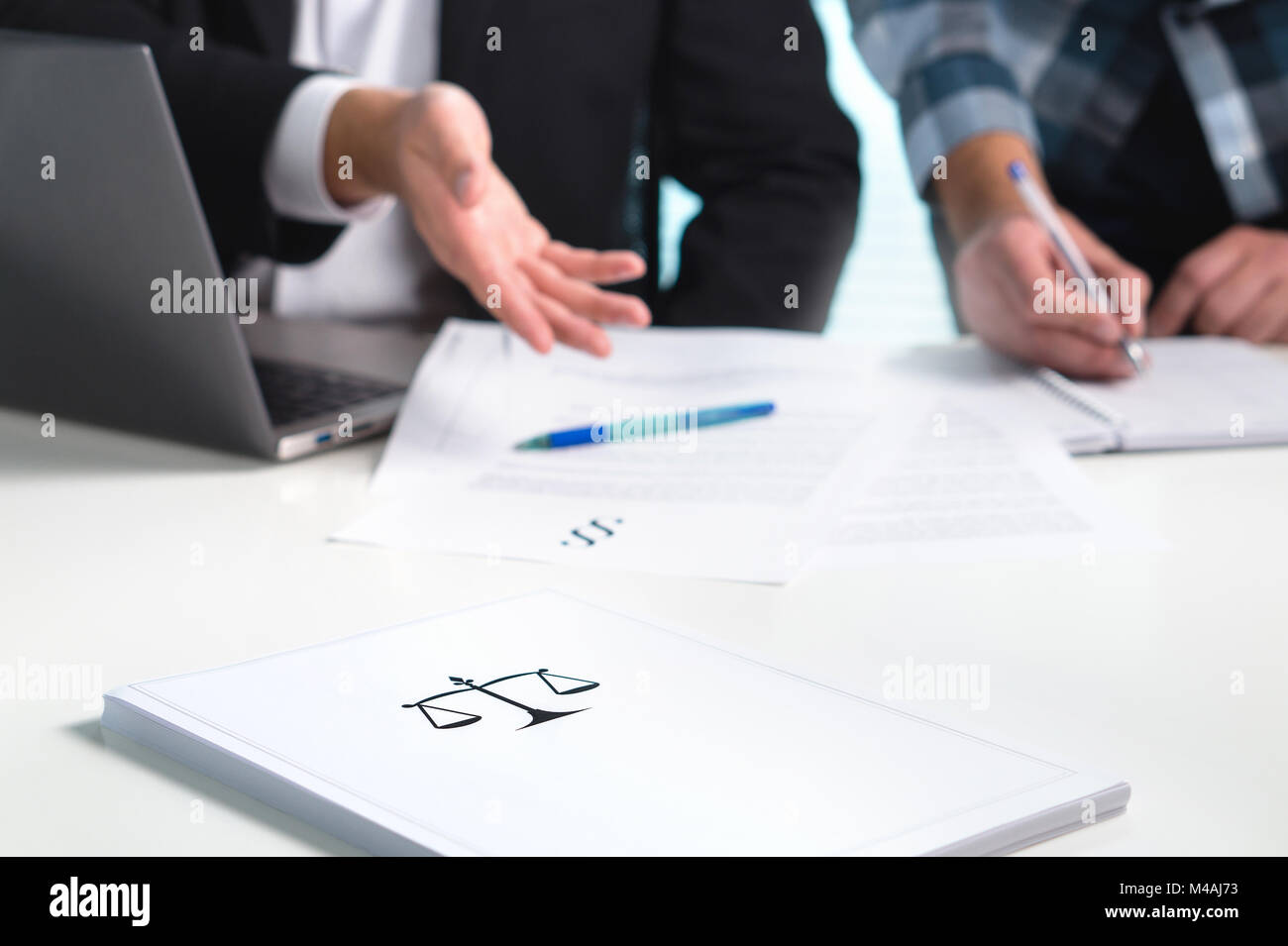 Team in law firm working in office. Lawyers discussing and writing. Business people having legal meeting. Pile of paper on table with scale. Stock Photo