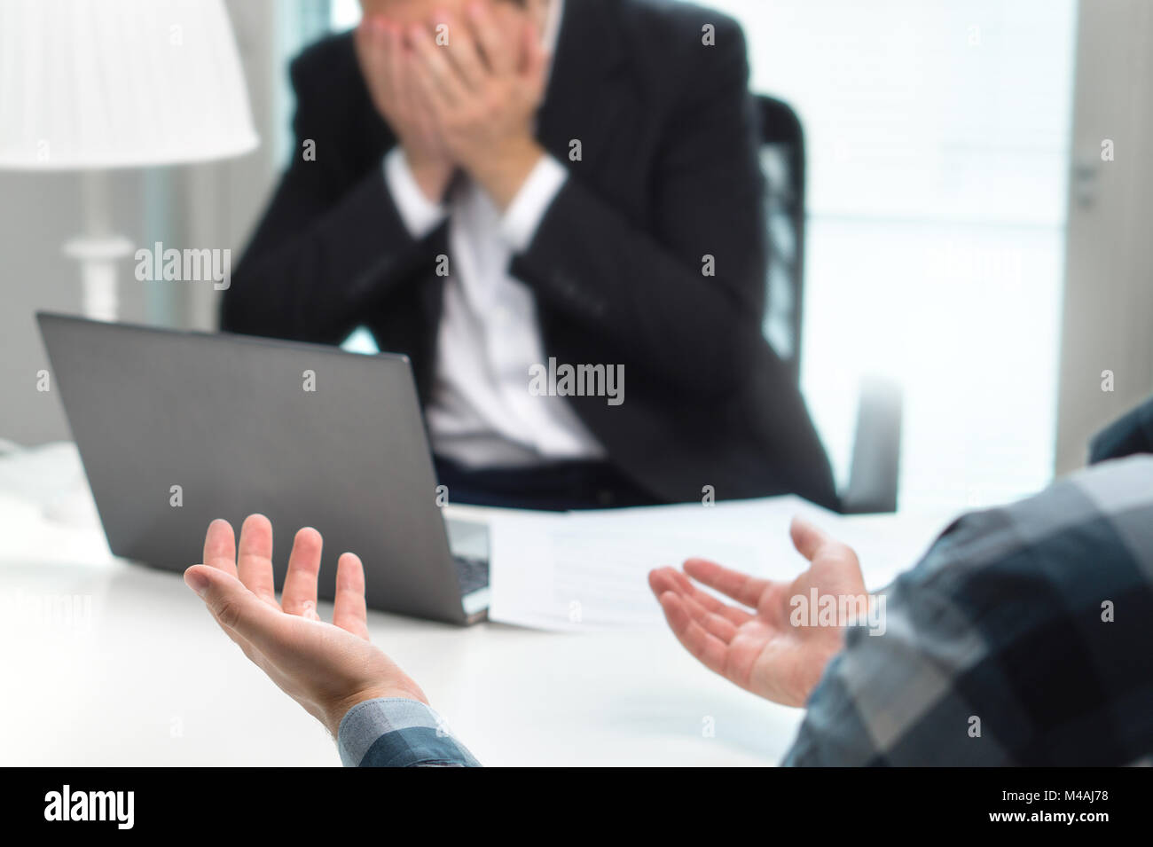 Failed job interview or business people having fight in office. Businessman covering and holding face with hands in meeting. Boss do not want to fire. Stock Photo