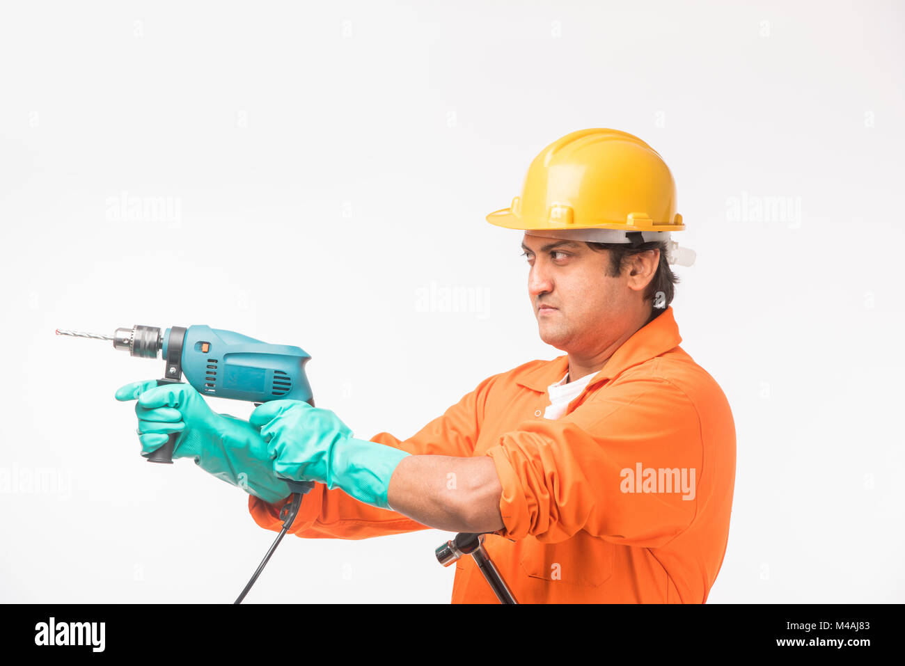 Indian electrician engineer in action with wire cutter, drilling machine etc, standing isolated over white background Stock Photo