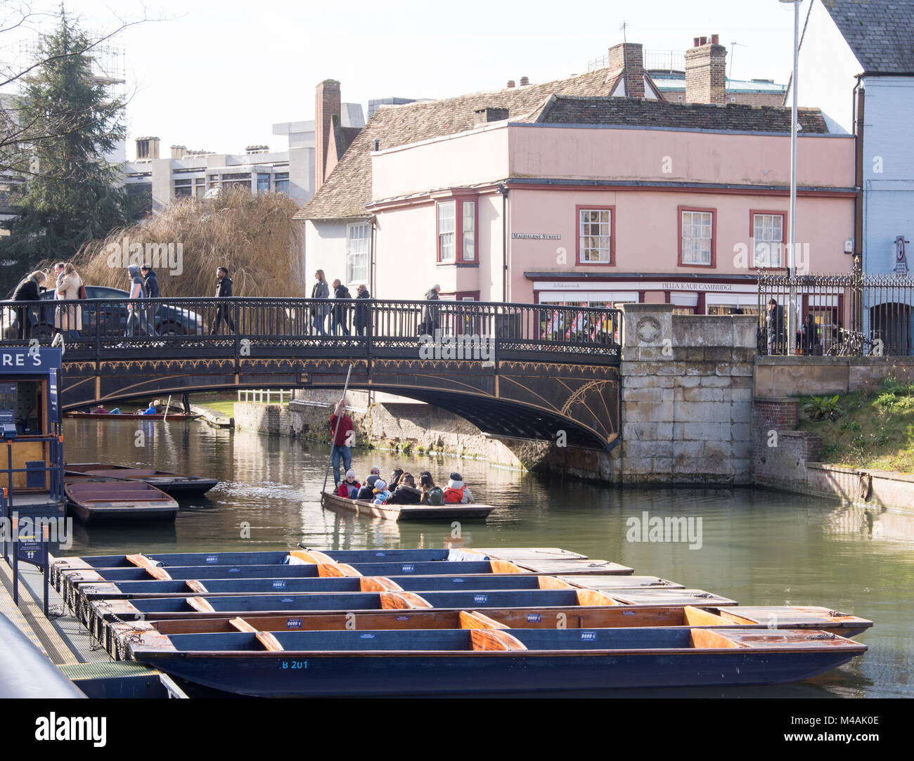 Tourists in Cambridge UK, February 12 2018, enjoying the classic recreation of punting on the River Cam by Magdalene Bridge in the sunshine of a fine  Stock Photo