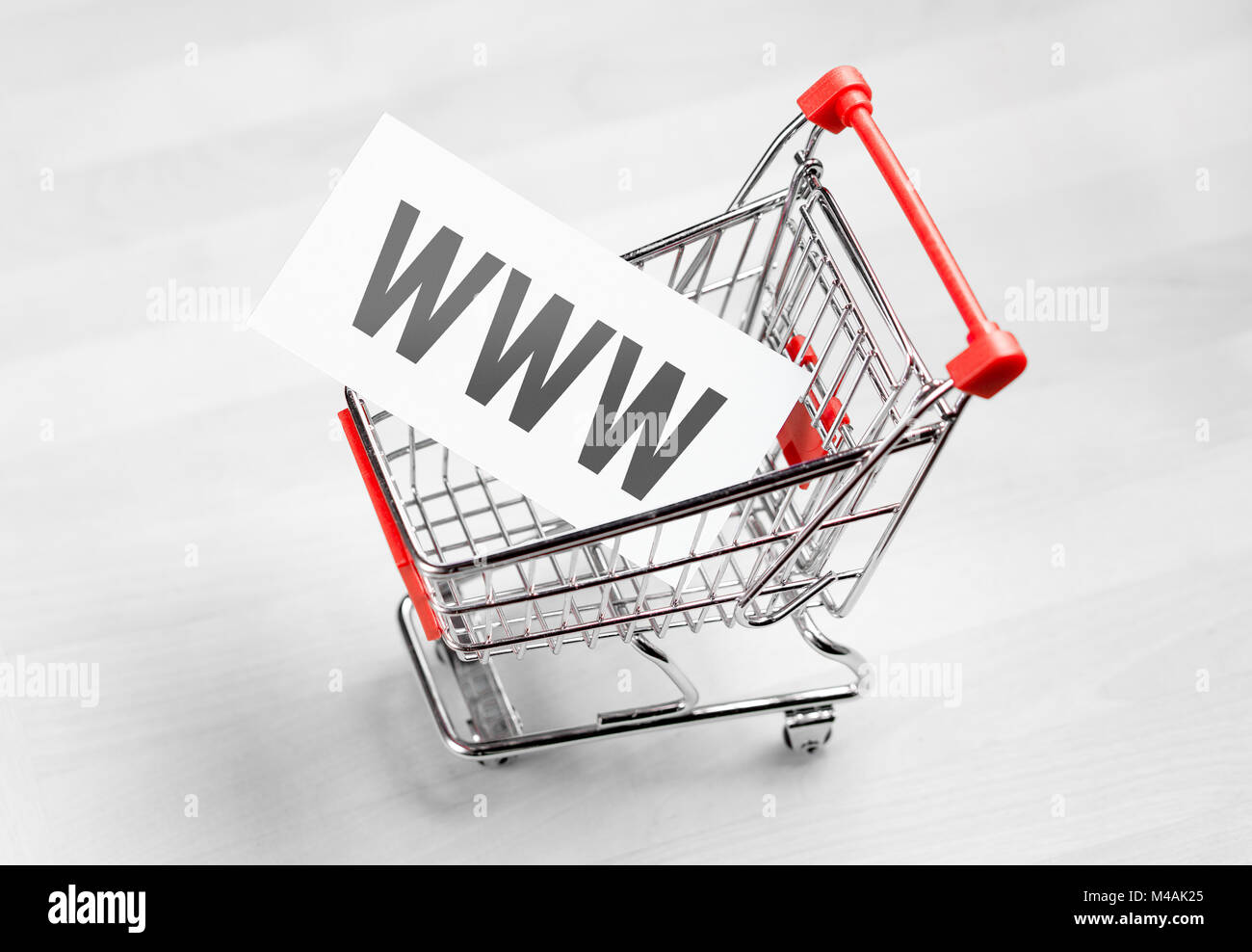 Buying domain name for company website. Online shopping, e commerce and internet store concept. Newsletter and email marketing. Miniature shopping car Stock Photo