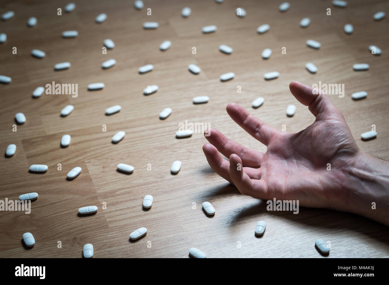 Drug addiction, medical abuse and narcotics hook and dependence concept. Drug addict with withdrawal symptoms lying on floor. Tablet overdose. Depress Stock Photo