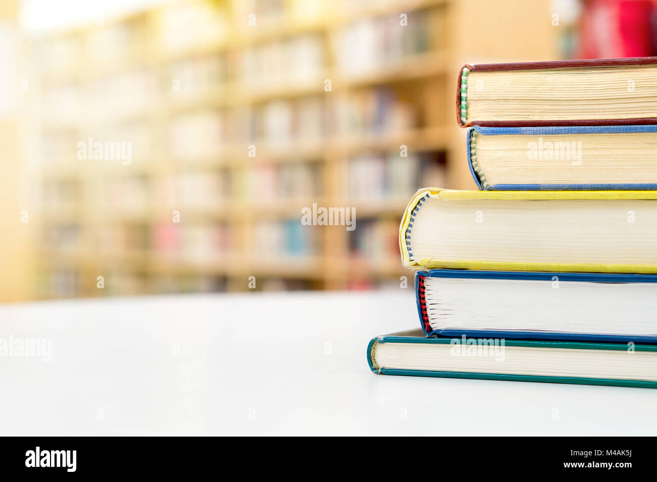 Stack and pile of books on table in public or school library. Education, studying and literature service concept with negative copy space. Stock Photo