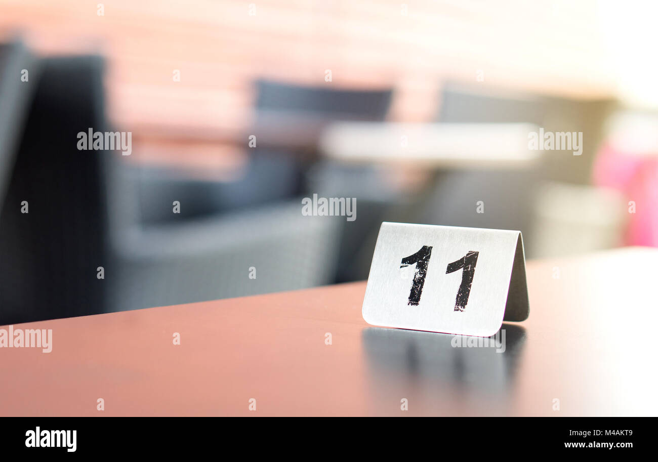 Number sign on restaurant table in outdoor terrace to show reservation. Customer waiting for service or food. Stock Photo