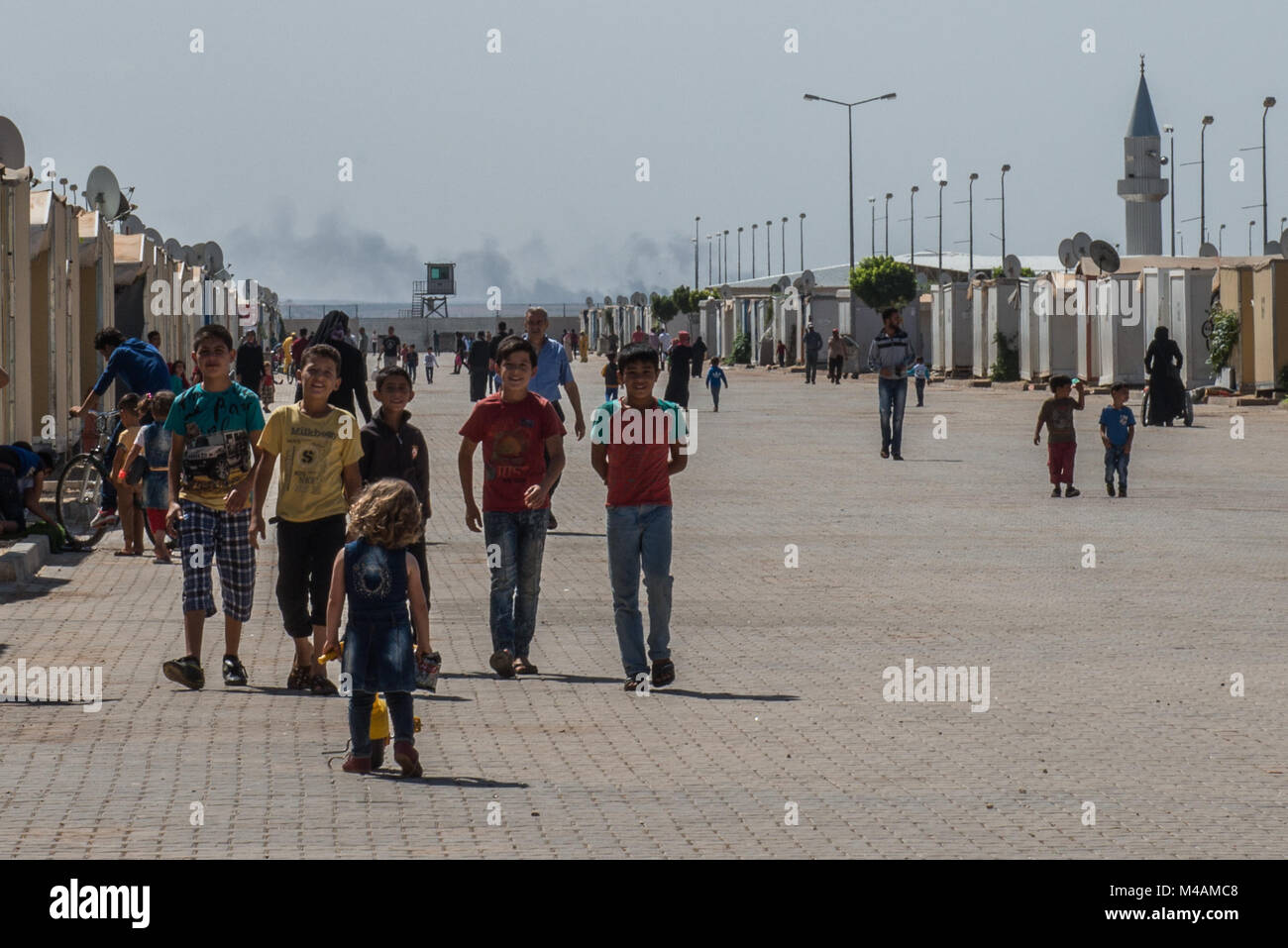 A group of refugee children walks down the main street of the Kilis refugee camp in Turkey, near the border with Syria. Stock Photo