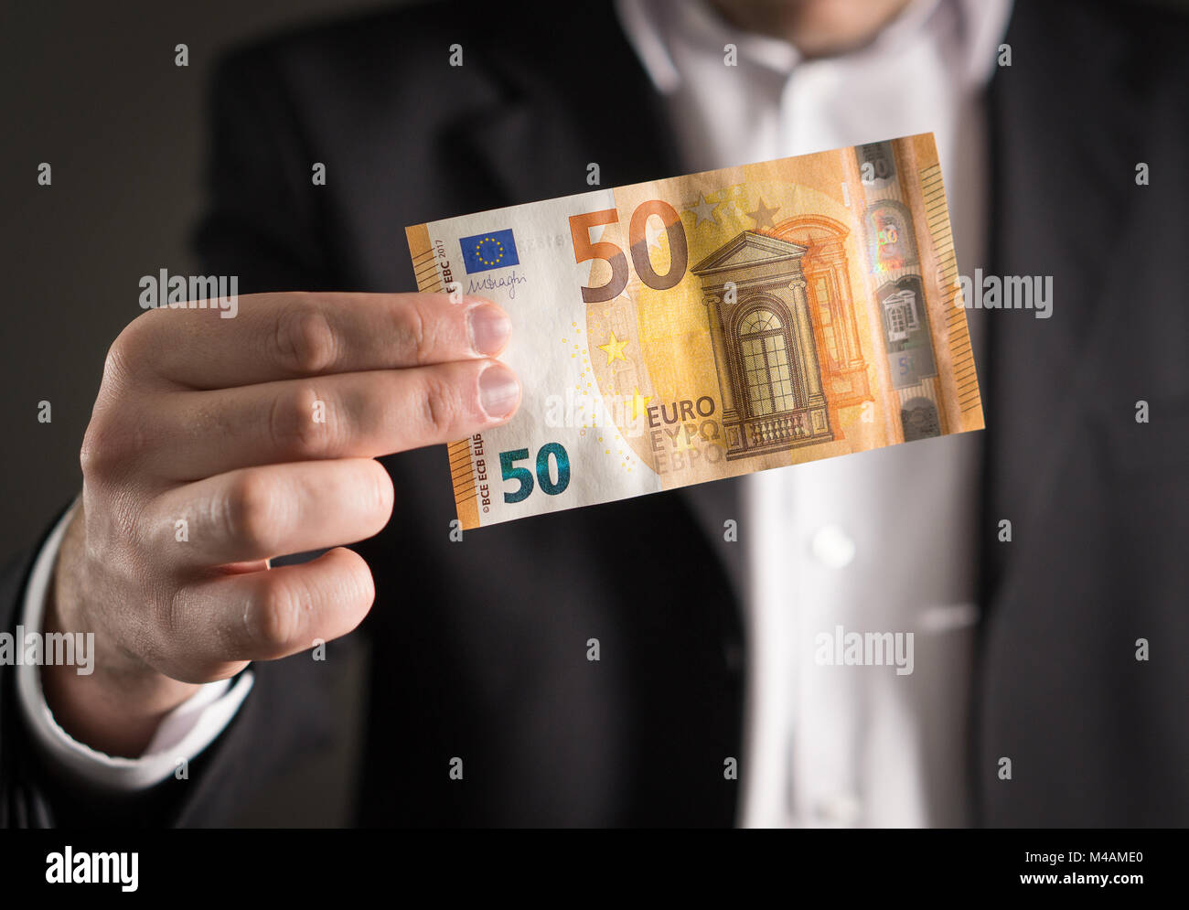 Business man in suit holding the new 50 euro banknote and bill. Stock Photo